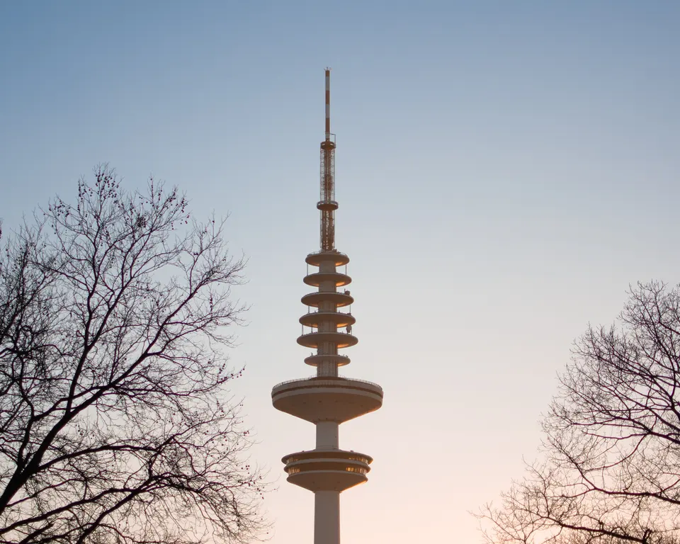 Hamburg's television tower between bare trees at dusk